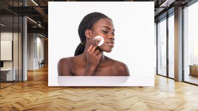 Portrait of beautiful african woman cleaning her face with cotton swab isolated on white background Wall mural